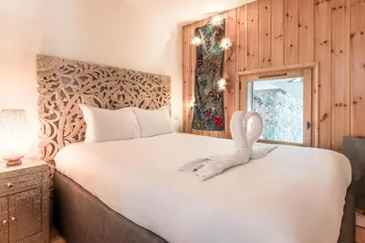 two swans sitting on top of a bed at Les jardins de Taconnaz - Les Houches in Les Houches