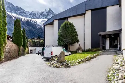 a car parked outside of a building with mountains in the background at Sun Valley 1 - calme - Acces bus - Proche lac in Chamonix-Mont-Blanc
