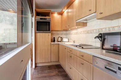 a kitchen with wooden cabinets and a counter top at Sun Valley 1 - calme - Acces bus - Proche lac in Chamonix-Mont-Blanc