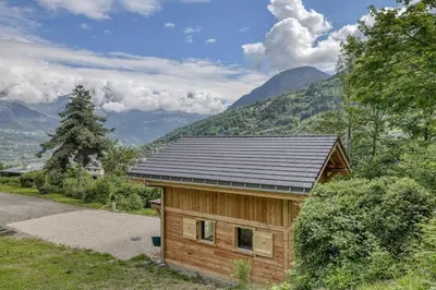 a small wooden cabin with a black roof at Chalet Marie situé 25km Chamonix in Saint-Gervais-les-Bains
