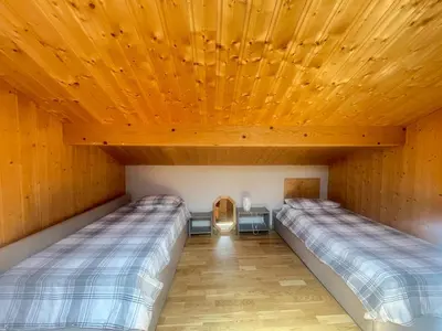 two beds in a room with a wooden ceiling at Alpine Escape Mont Blanc at Your Window in Chamonix-Mont-Blanc