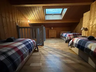 a attic room with two beds and a window at Alpine Escape Mont Blanc at Your Window in Chamonix-Mont-Blanc