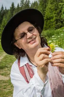 a woman wearing a hat holding flowers in her hands at Marc VEYRAT in Megève