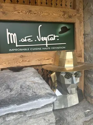 a glass of wine sitting on a tree stump at Marc VEYRAT in Megève