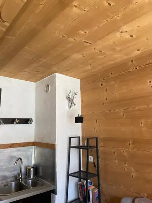 a kitchen with wooden ceilings and a sink and a ladder at Magnifique Studio Plein centre vue panoramique in Chamonix-Mont-Blanc