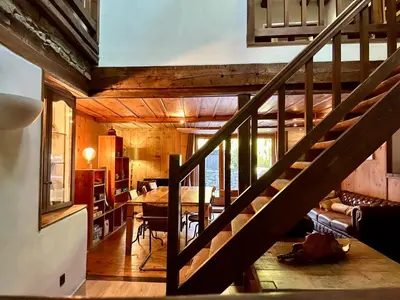 a staircase leading to a living room and a dining room at Marmotte Mountain Manor in Chamonix-Mont-Blanc