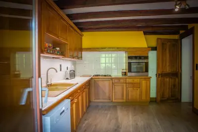 a kitchen with wooden cabinets and a yellow wall at Marmotte Mountain Manor in Chamonix-Mont-Blanc