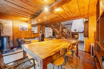 a dining room with a large wooden table and chairs at Marmotte Mountain Manor in Chamonix-Mont-Blanc