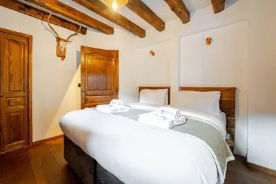 a bedroom with a large white bed in a room at Marmotte Mountain Manor in Chamonix-Mont-Blanc