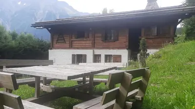 a wooden picnic table in front of a building at Résidence plein sud en vallée de Chamonix in Les Houches