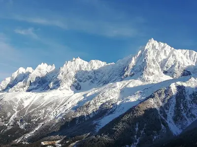a snow covered mountain range with snow covered mountains at Résidence plein sud en vallée de Chamonix in Les Houches