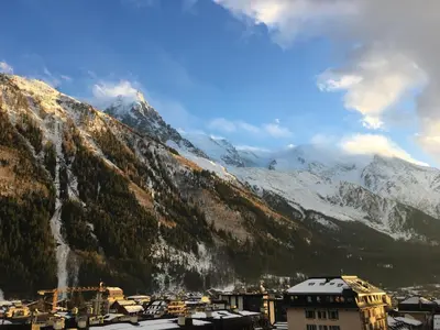 a view of a city with snow covered mountains at Plein centre vue panoramique exceptionnelle Sud très grand studio in Chamonix-Mont-Blanc