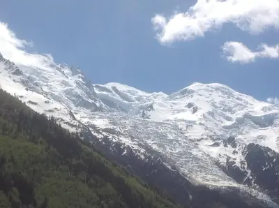 a snow covered mountain with trees in front of it at Plein centre vue panoramique exceptionnelle Sud très grand studio in Chamonix-Mont-Blanc