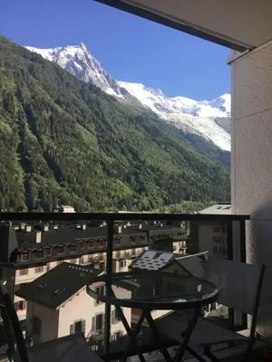 a balcony with a table and a view of a mountain at Plein centre vue panoramique exceptionnelle Sud très grand studio in Chamonix-Mont-Blanc