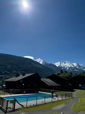 a swimming pool with snow capped mountains in the background at Le Cozet in Saint-Gervais-les-Bains