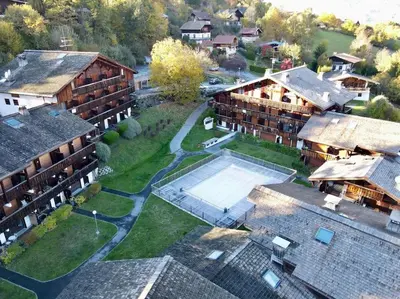 an aerial view of a resort with a pool and buildings at Le Cozet in Saint-Gervais-les-Bains