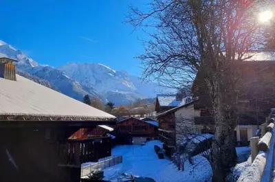 a snow covered village with mountains in the background at Le Cozet in Saint-Gervais-les-Bains