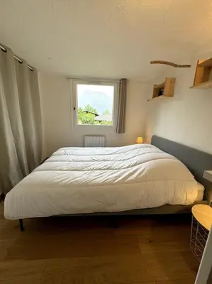 a bedroom with a large bed with a window at Le Cozet in Saint-Gervais-les-Bains