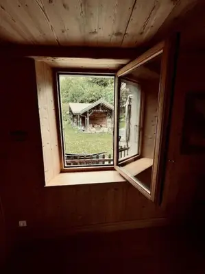 a window in a room with a view of a house at La ferme de la Tour - Vallée de Chamonix in Servoz