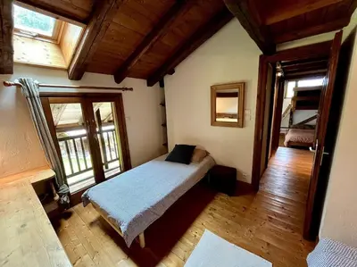 a bedroom with a bed in a room with windows at La ferme de la Tour - Vallée de Chamonix in Servoz