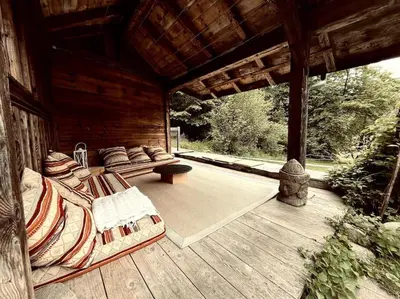 a porch of a wooden cabin with chairs and a bench at La ferme de la Tour - Vallée de Chamonix in Servoz