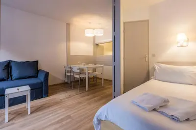 a bedroom with a bed with white sheets and pillows at Slalom Residence Chamois Blanc in Chamonix-Mont-Blanc