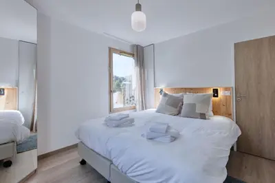 a bedroom with a large white bed with white pillows at Alpina 108 départ ski & rando depuis le Bettex in Saint-Gervais-les-Bains
