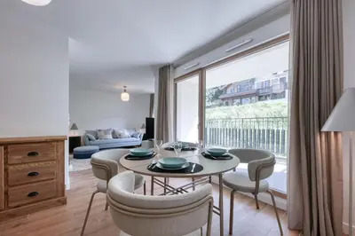 a living room with a table and chairs and a large window at Alpina 108 départ ski & rando depuis le Bettex in Saint-Gervais-les-Bains