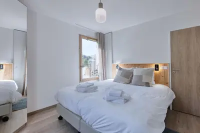 a bedroom with a large white bed with white pillows at Alpina 108 départ ski & rando depuis le Bettex in Saint-Gervais-les-Bains