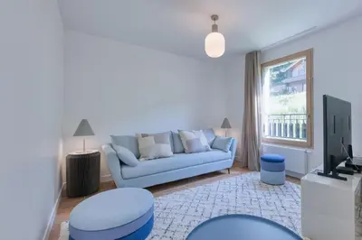 a living room with a blue couch and a window at Alpina 108 départ ski & rando depuis le Bettex in Saint-Gervais-les-Bains