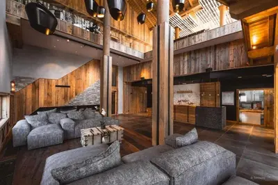 a large living room with couches and a staircase at L'Eclat des Veriaz - Megève Appartement 2 chambres, Résidence de standing in Megève