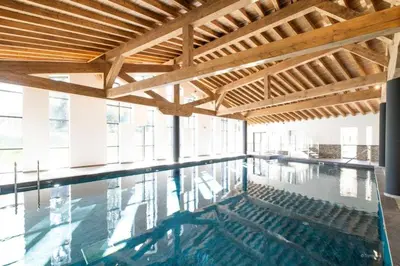 an indoor swimming pool with a wooden ceiling at L'Eclat des Veriaz - Megève Appartement 2 chambres, Résidence de standing in Megève
