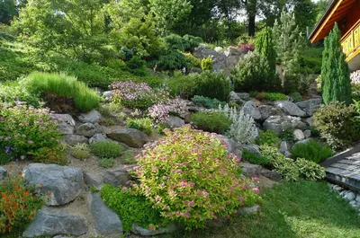 a garden with rocks and flowers in a yard at Location de charme 4 étoiles à Passy in Passy