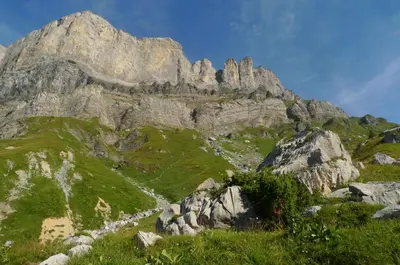 a mountain with green grass and rocks on it at Location de charme 4 étoiles à Passy in Passy