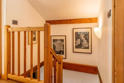 a staircase in a home with two pictures on the wall at Balcon de l'Arve - Charming Duplex in Chamonix Centre in Chamonix-Mont-Blanc