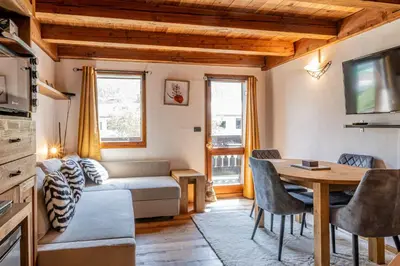 a living room with a couch and a table at Balcon de l'Arve - Charming Duplex in Chamonix Centre in Chamonix-Mont-Blanc
