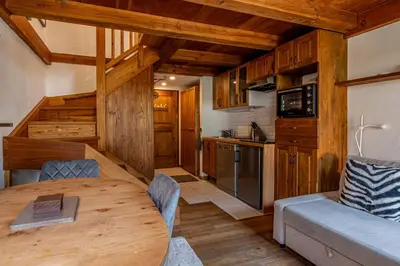 a kitchen and dining room with a table in a cabin at Balcon de l'Arve - Charming Duplex in Chamonix Centre in Chamonix-Mont-Blanc