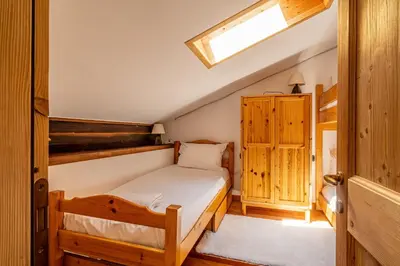 a bedroom with a bed and a wooden cabinet at Balcon de l'Arve - Charming Duplex in Chamonix Centre in Chamonix-Mont-Blanc