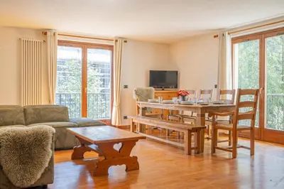a living room with a table and a couch at Coeur des Alpes - A spacious 3-bedroom apartment with spectacular views in Chamonix-Mont-Blanc