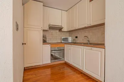 a kitchen with white cabinets and a microwave at Coeur des Alpes - A spacious 3-bedroom apartment with spectacular views in Chamonix-Mont-Blanc