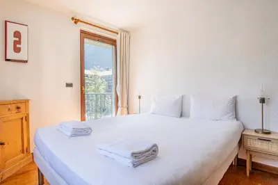 a bedroom with a large white bed with towels on it at Coeur des Alpes - A spacious 3-bedroom apartment with spectacular views in Chamonix-Mont-Blanc