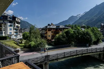 a bridge over a river in a city with buildings at Coeur des Alpes - A spacious 3-bedroom apartment with spectacular views in Chamonix-Mont-Blanc