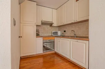 a kitchen with white cabinets and a microwave at Coeur des Alpes - A spacious 3-bedroom apartment with spectacular views in Chamonix-Mont-Blanc