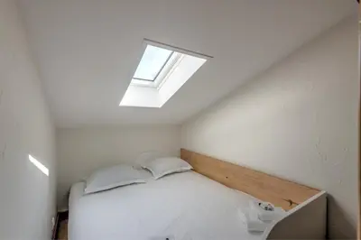a small bedroom with a bed and a skylight at Duplex de Miage - Welkeys in Saint-Gervais-les-Bains