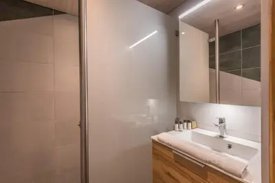 a bathroom with a sink and a shower at Duplex de Miage - Welkeys in Saint-Gervais-les-Bains