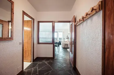 a hallway with a door and a room with a table at Appartement l'Olympique - Ski in & ski out in Megève