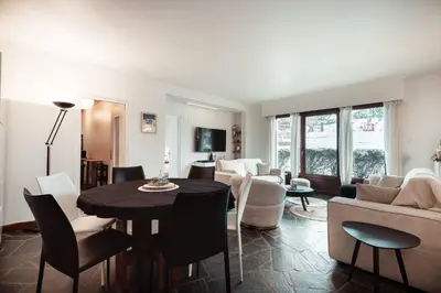 a living room with a table and chairs and a couch at Appartement l'Olympique - Ski in & ski out in Megève