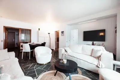 a living room with two white couches and a table at Appartement l'Olympique - Ski in & ski out in Megève