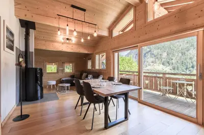 a dining room with a table and chairs and a large window at Les Trabets - Bellevue telecabine - Renove in Les Houches