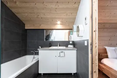 a bathroom with a white sink and a bath tub at Les Trabets - Bellevue telecabine - Renove in Les Houches